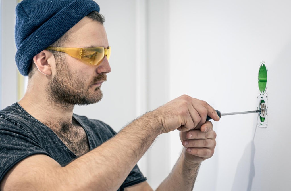 Ein Handwerker arbeitet an der elektrischen Installation.