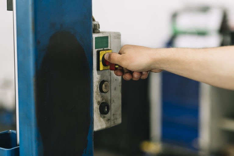 Jemand betätigt den Not-Aus-Schalter am Tor